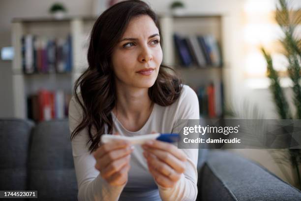 thoughtful young woman waiting for pregnancy test result - resultados de exames médicos imagens e fotografias de stock
