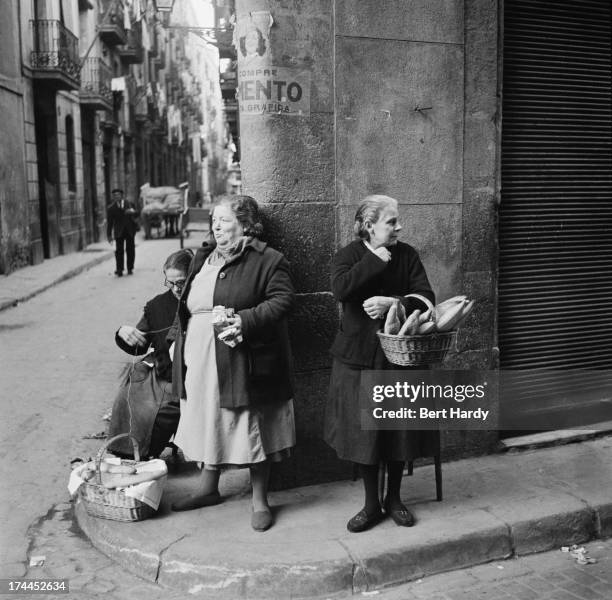 Group of women with baskets of bread on a street corner in Barcelona, Spain, April 1951. Original publication: Picture Post - 5243 - Barcelona a City...