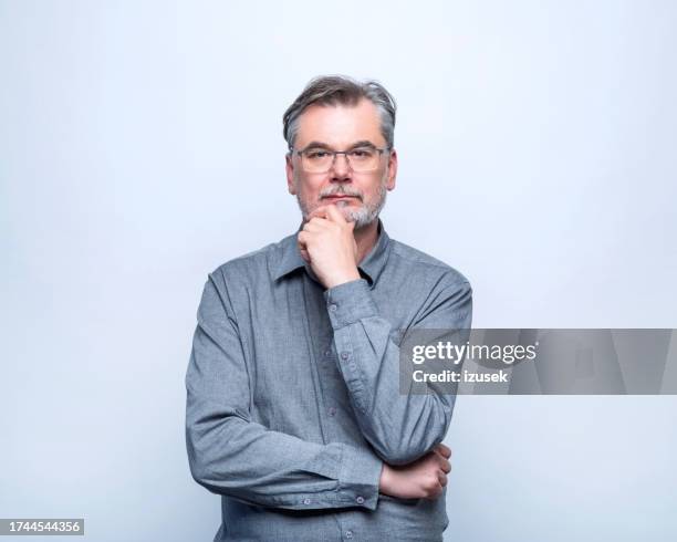 portrait of thoughful mature man - hand on chin stock pictures, royalty-free photos & images