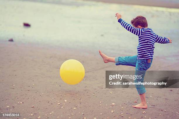 boy kicking ball on beach - kicking sand stock pictures, royalty-free photos & images