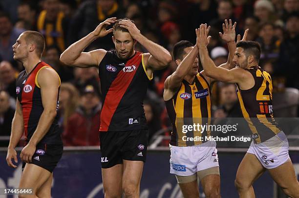 David Zaharakis and Cale Hooker of the Bombers react as Shane Savage and Paul Puopolo of the Hawks celebrate a goal during the round 18 AFL match...