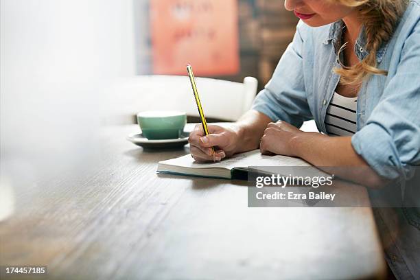 woman working in a coffee shop - hand writing foto e immagini stock