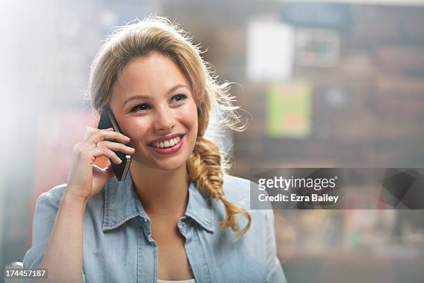 woman on her mobile phone in a coffee shop - 25 years stock pictures, royalty-free photos & images