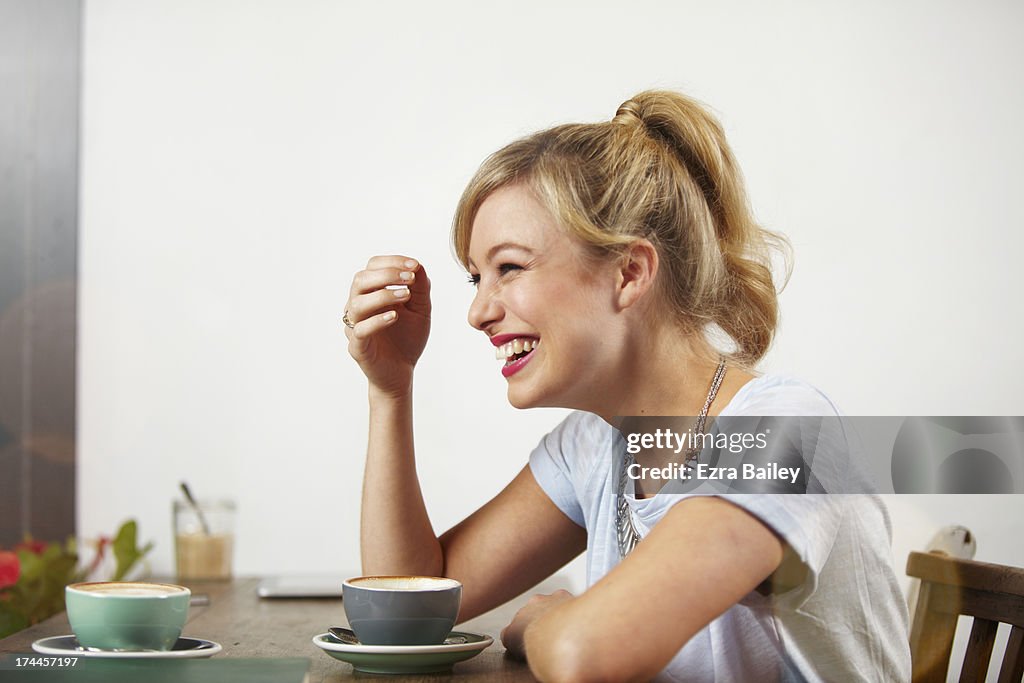 Woman laughing in a coffee shop