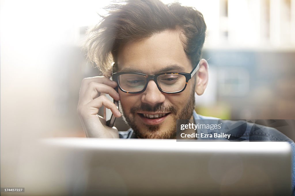 Man on the phone and using laptop