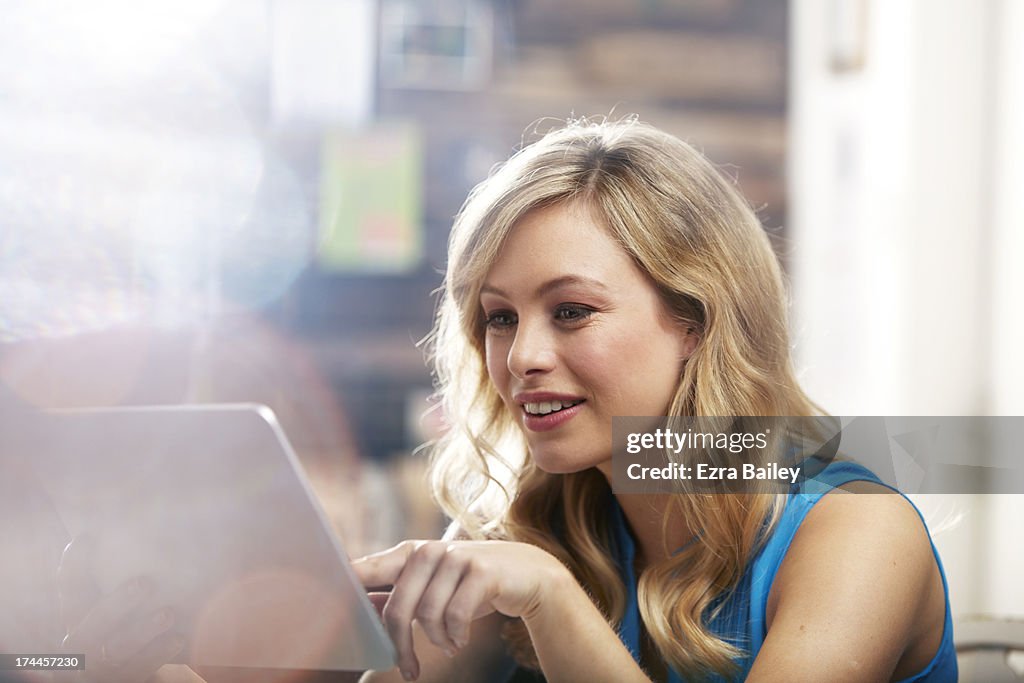 Woman using a tablet in a coffee shop.