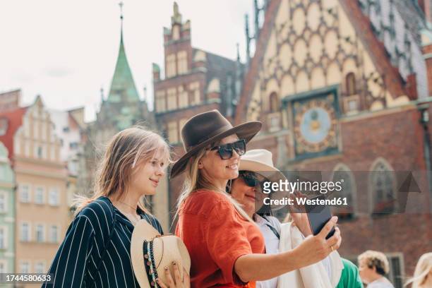happy family taking selfie through smart phone in front of building - fashionable grandma stock pictures, royalty-free photos & images