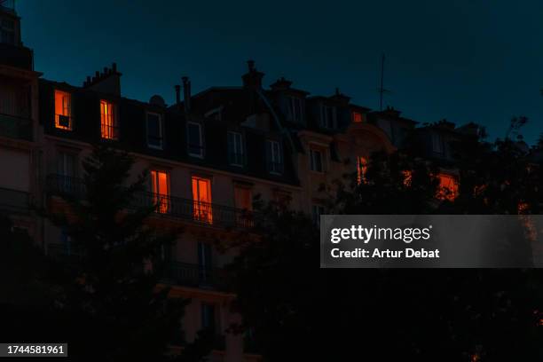 paris apartment with illuminated windows at night. - paris night stock pictures, royalty-free photos & images