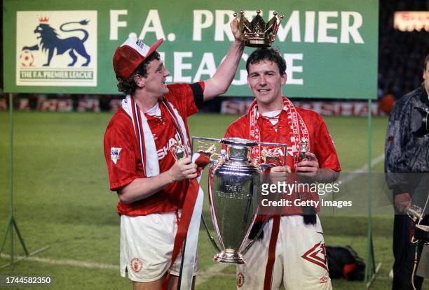 Manchester United captains Steve Bruce and Bryan Robson hold aloft the FA Premier League trophy after the final home game of the 1992/93 season,...