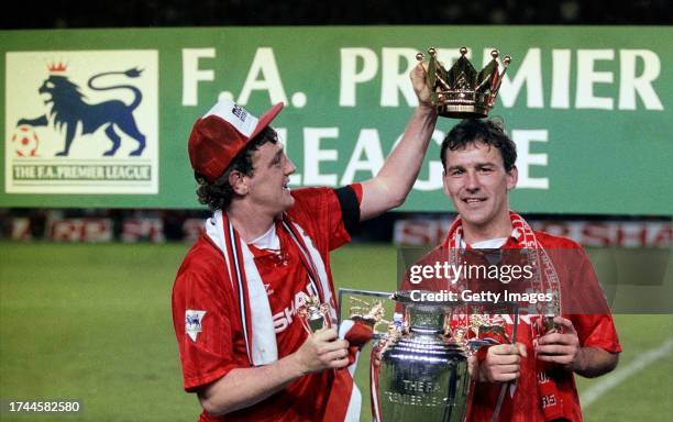 Manchester United captains Steve Bruce and Bryan Robson hold aloft the FA Premier League trophy after the final home game of the 1992/93 season,...