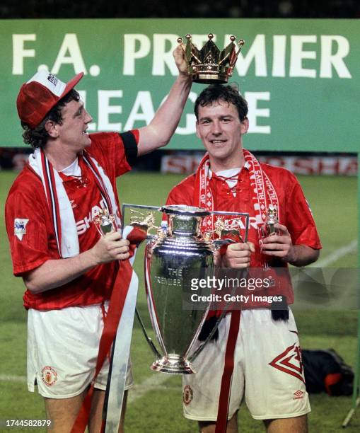 Manchester United captains Steve Bruce and Bryan Robson hold aloft the FA Premier League trophy after the final home game of the 1992/93 season,...