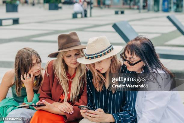 woman using smart phone with family - fashionable grandma stock pictures, royalty-free photos & images