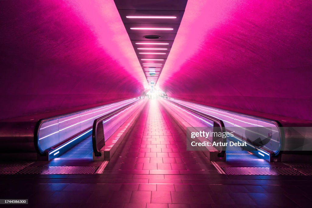 Psychedelic red subway corridor in Paris with moving walkway.