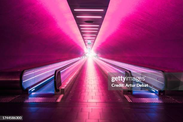 psychedelic red subway corridor in paris with moving walkway. - paris airport stock pictures, royalty-free photos & images