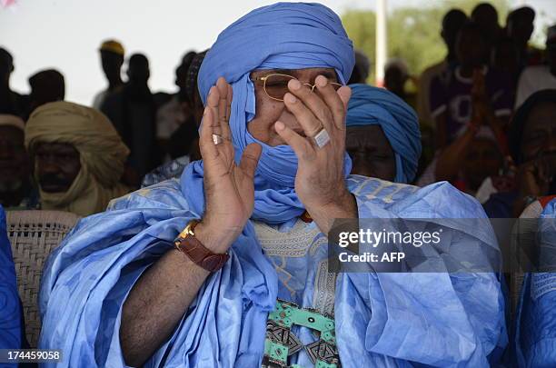 Assarid Ag Imbarcaouane, a Tuareg parliament member, applauds as he attends a campaign meeting of The Alliance for Democracy in Mali presidential...