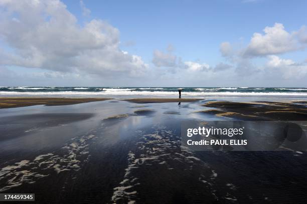Man takes photographs by the sea at Karekare in New Zealand on October 18 during the 2011 Rugby World Cup. AFP PHOTO/PAUL ELLIS