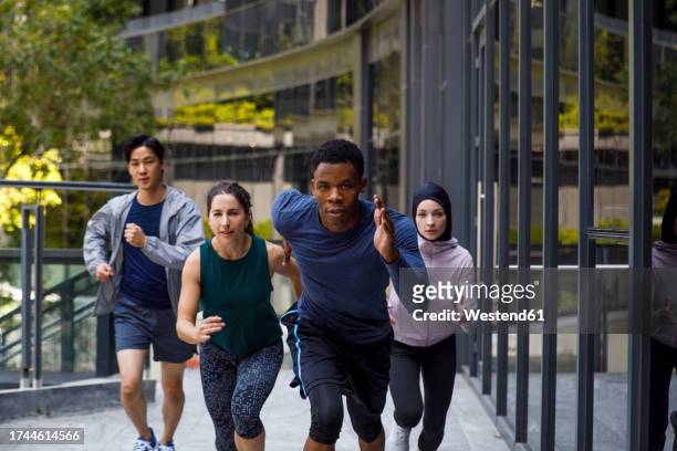 determined man running with friends on footpath - islamic action front stock pictures, royalty-free photos & images