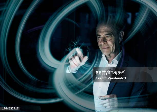 digital composite image of businessman creating swirl pattern on graphical user interface - business stock illustrations