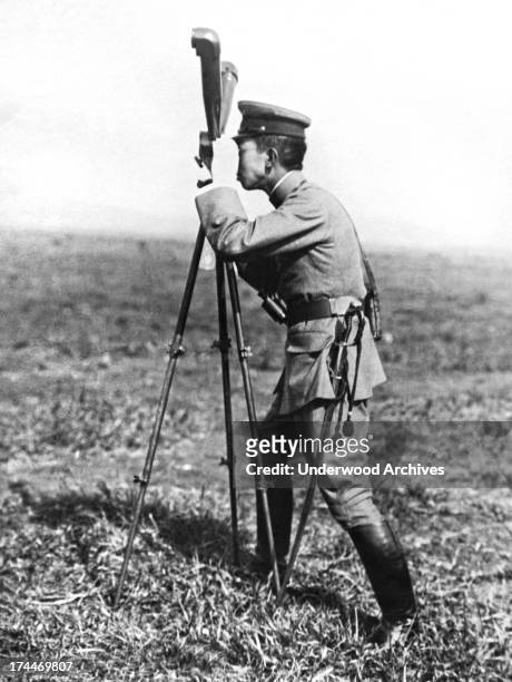 Prince Hirohito looking through the range finder at military maneuvers in Japan, December 6, 1922.
