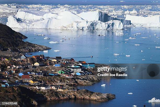 The village of Ilulissat is seen near the icebergs that broke off from the Jakobshavn Glacier on July 24, 2013 in Ilulissat, Greenland. As the sea...