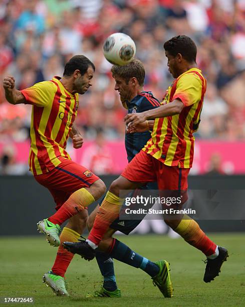 Thomas Mueller of Muenchen is chllenged by Martin Montoya of Barcelona during the Uli Hoeness cup match between FC Bayern Munich and FC Barcelona at...