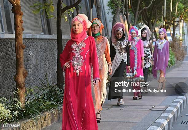 Muslim models wear Bohemian Kaftan by Amelia in a fashion show as Ramadan observers break their fast on July 26, 2013 in Surabaya, Indonesia....