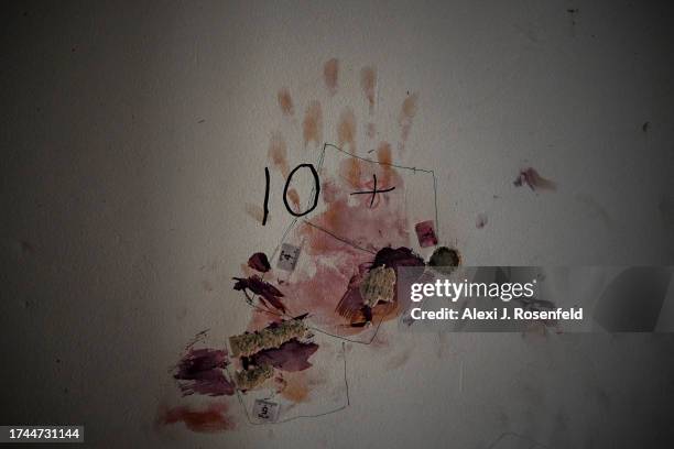 Bloodied handprint stains a wall in a house after Hamas militants attacked this kibbutz days earlier near the border of Gaza on October 19, 2023 in...