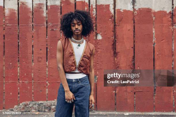 portrait de jeune homme contre un mur rouge - street style photos et images de collection