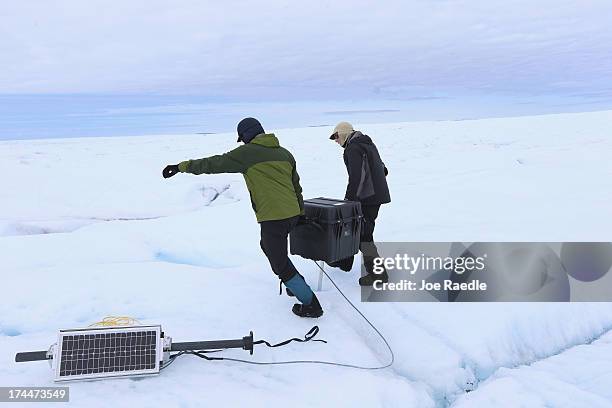 David Shean a Ph.D. Student at the University of Washington and Scientist Ian Joughin of the University of Washington place a GPS system into place...