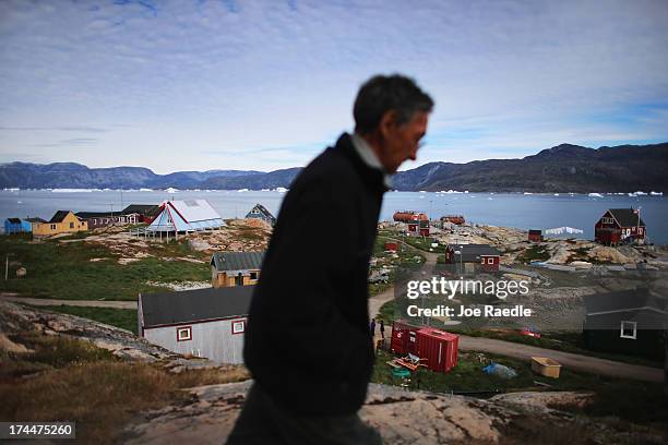 Person walks through the village on July 20, 2013 in Qeqertaq, Greenland. As Greenlanders adapt to the changing climate and go on with their lives,...