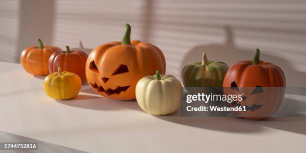 plastic pumpkins and jack o lanterns lying on white surface - smiley face stock pictures, royalty-free photos & images