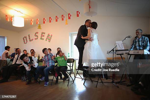 Newly weds, Adam Olsen and Ottilie Olsen kiss as they stand on chairs on July 20, 2013 in Qeqertaq, Greenland. As the sea levels around the globe...