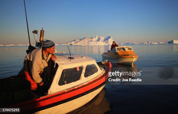 Fisherman, Inunnguaq Petersen, heads to the spot where he put in his fishing line near icebergs that broke off from the Jakobshavn Glacier on July...