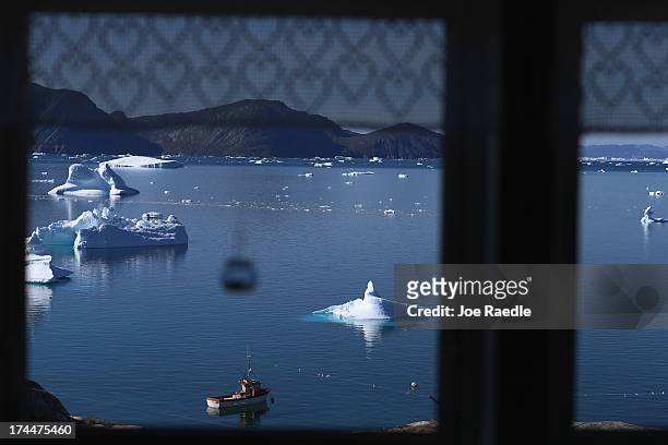 Icebergs are seen through a kitchen window on July 20, 2013 in Qeqertaq, Greenland. As the sea levels around the globe rise, researchers affilitated...