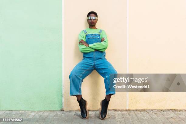 young woman wearing smart glasses leaning on multi colored wall - tip toe stock pictures, royalty-free photos & images