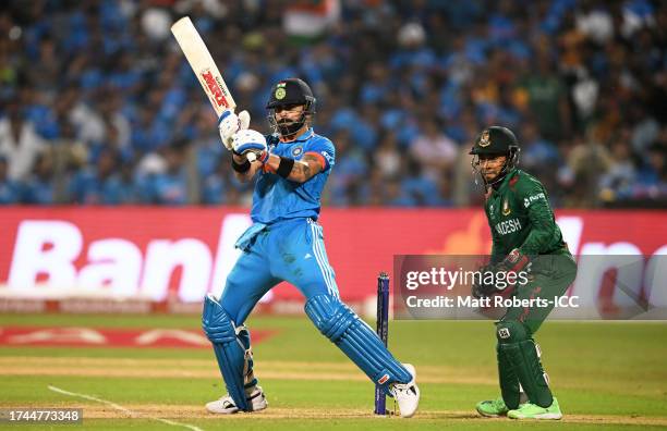 Virat Kohli of India plays a shot as Mushfiqur Rahim of Bangladesh keeps during the ICC Men's Cricket World Cup India 2023 between India and...