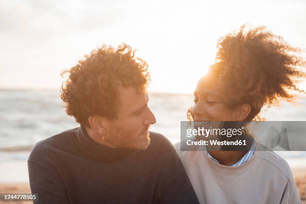 happy couple spending leisure time at beach on sunny day - adult couple stock pictures, royalty-free photos & images