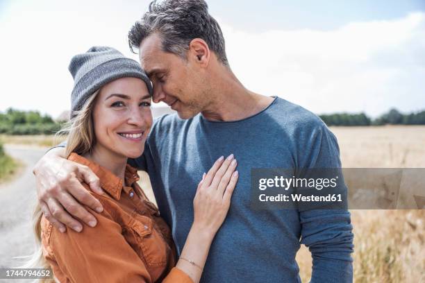 affectionate couple spending leisure time near field - falling in love stock pictures, royalty-free photos & images