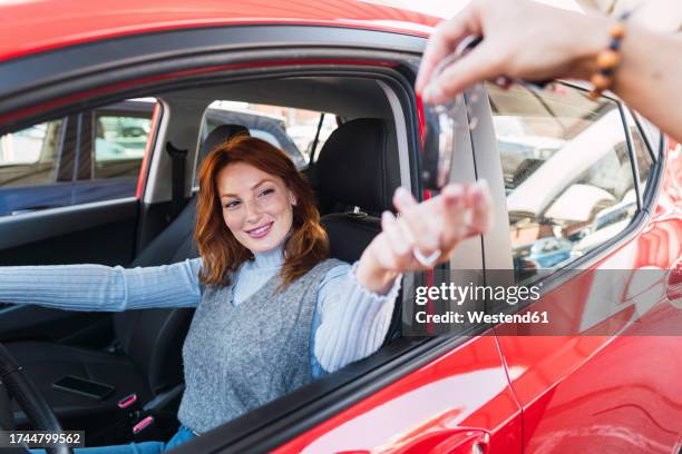 smiling woman taking car keys from man - car rental stock pictures, royalty-free photos & images
