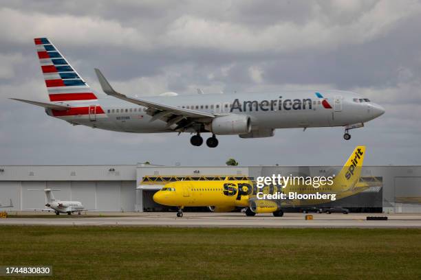 Spirit Airlines airplane taxis as an American Airlines airplane lands at Fort Lauderdale-Hollywood International Airport in Fort Lauderdale, Florida,...