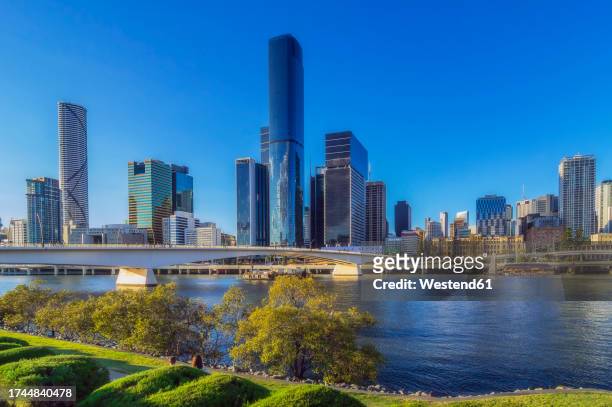 australia, queensland, brisbane, skyline of riverside city with bridge in foreground - brisbane river stock pictures, royalty-free photos & images