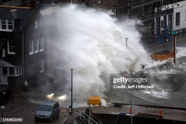 Waves crash over the harbour on October 19, 2023 in Stonehaven, Scotland. Rare Red weather warnings are in place in Scotland and amber warnings in...