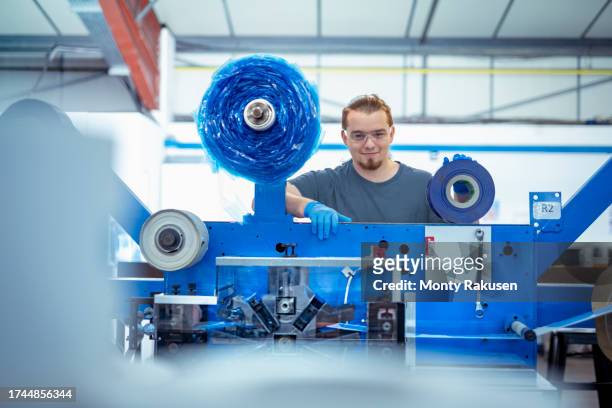 factory worker with assembly machine in factory - preston england stock pictures, royalty-free photos & images