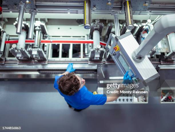 factory worker at controls of adhesive tape manufacturing machine in factory - preston england stock pictures, royalty-free photos & images