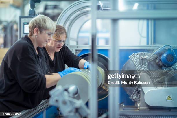 workers setting up adhesive tape cutting machine in factory - preston england stock pictures, royalty-free photos & images