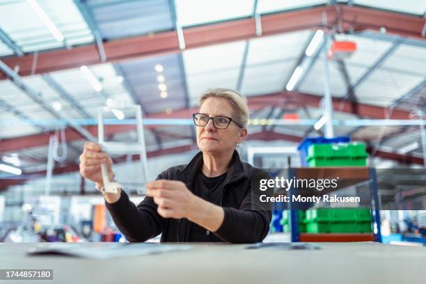 worker making gaskets from specialist adhesive tape in factory - preston england stock pictures, royalty-free photos & images