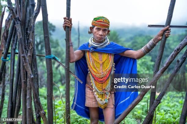 clse up portrait of a woman from the bonda tribe with the jungle on the backside of the indian region of odisha. since 2012, india has placed restrictions on being able to visit this tribe. - tribal pattern stock pictures, royalty-free photos & images