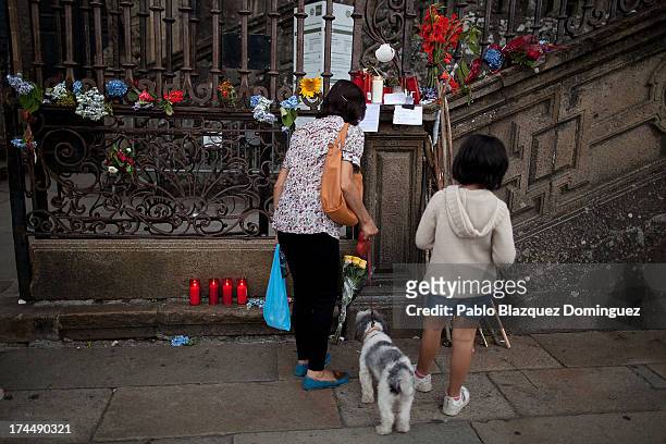 Woman reads messages for those killed in a train crash from the fence of the Cathedral in Plaza do Obradoiro on July 26, 2013 in Santiago de...