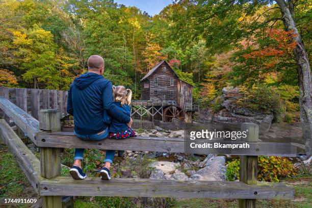 father and daughter exploring the glade creek grist mill in babcock state park during the fall season in the appalachian mountains of west virginia, usa. - 40 44 years blond hair mature man factory stock pictures, royalty-free photos & images