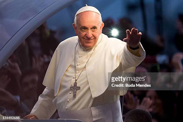 Pope Francis waves from the Popemobile on his way to attend the Via Crucis on Copacabana Beach during World Youth Day celebrations on July 26, 2013...